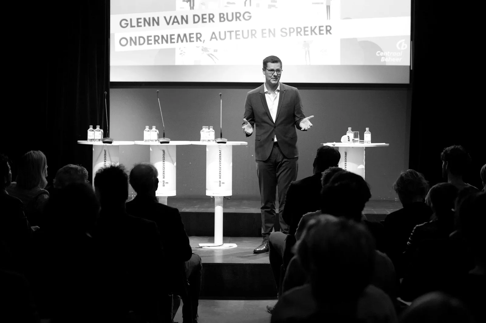 Glenn van der Burg als dagvoorzitter op het podium